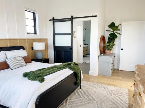 a bedroom with a bed with a green blanket on it at Black Barn Ranch 25 Acres Wpool Near Downtown in San Luis Obispo