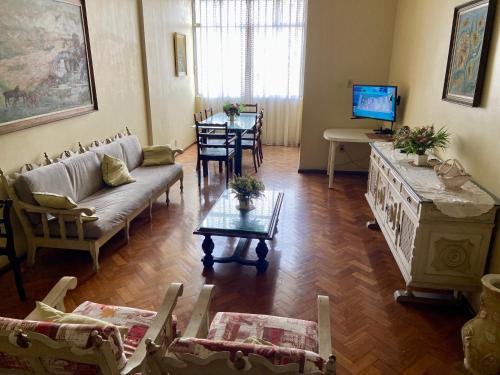 a living room with a couch and a table at São Salvador, Flamengo, 3 quartos in Rio de Janeiro