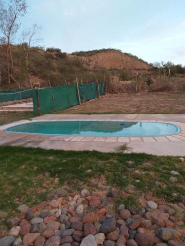 una piscina en un patio con una valla verde en Soñada casa con Pileta Pedriel II en Luján de Cuyo