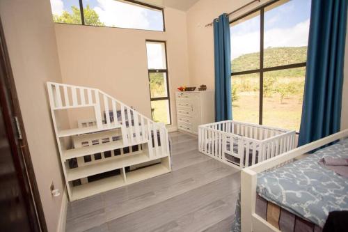 a bedroom with two white bunk beds and windows at Mountain View Villa 