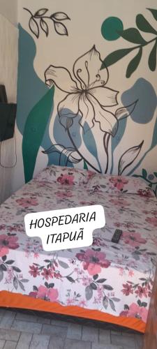 sypialnia z łóżkiem z malowidłem kwiatowym na ścianie w obiekcie HOSPEDARIA ITAPUÃ w mieście Santarém