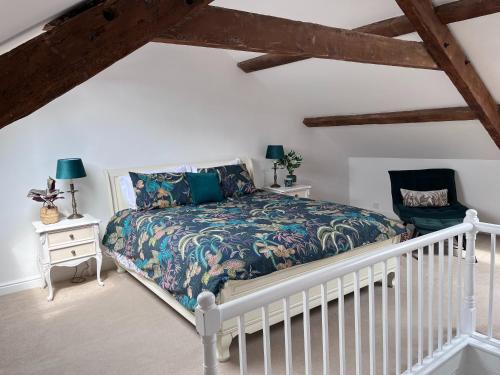 een slaapkamer met een bed en een stoel bij Tregwylan in Nefyn