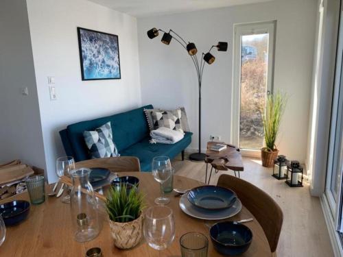 a living room with a table and a blue couch at Hausboot Moby Chic mit Dachterrasse in Kragenæs auf Lolland/DK in Torrig