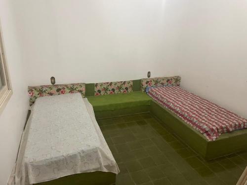 a room with a green bench and a mattress at Residencial Brilha Mar in Capão da Canoa