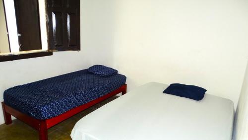 two beds sitting next to each other in a room at Hostal Madrid in Tapachula