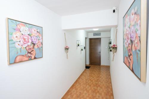 a hallway with paintings of flowers on the walls at Napa Centrale Suites in Ayia Napa