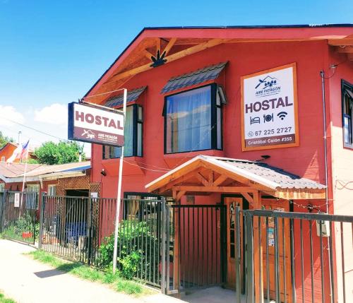 a red building with a hospital sign in front of it at HOSTAL AIRE PATAGON in Coihaique