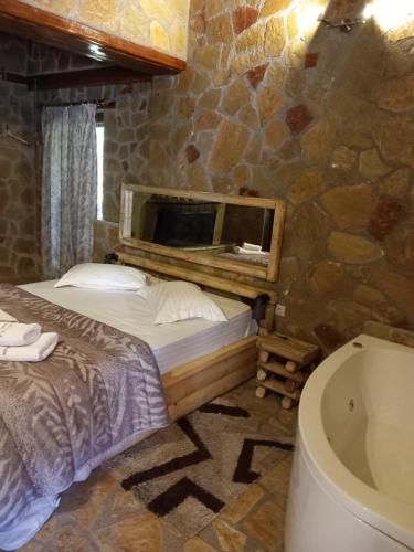 1 dormitorio con cama, bañera y lavamanos en eco oneiro resort, en Kalavrita