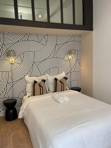 um quarto com uma cama branca e uma parede em preto e branco em Suite Detroit em Lyon