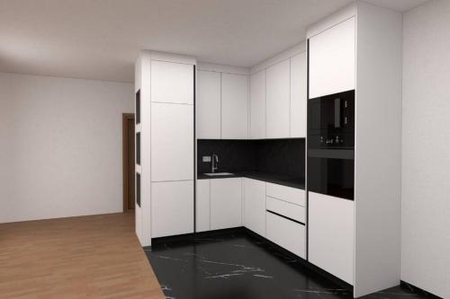 une cuisine avec des armoires blanches et des appareils noirs dans l'établissement Apartment for rent in Deçan, à Deçan