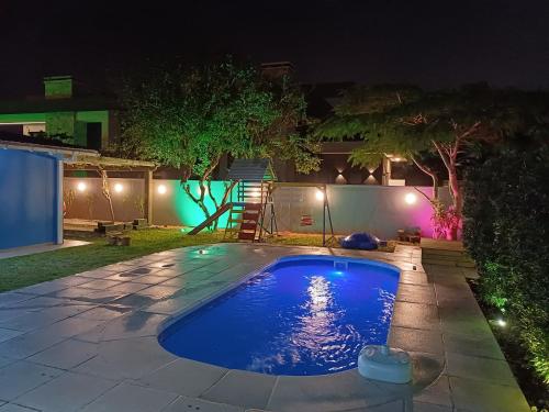 a swimming pool in a yard at night at Casa em Atlântida com Piscina in Xangri-lá