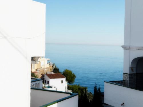 a view of the ocean from between buildings at Stunning Duplex in Capistrano Playa, Nerja in Nerja
