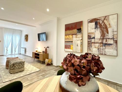 a living room with a vase of flowers on a table at Estudio con encanto en el casco, junto al puerto in Castro-Urdiales