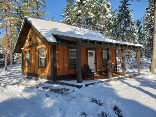 eine Hütte im Wald im Schnee in der Unterkunft Whispering Pines cabins in Lakeside