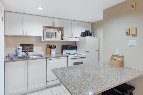 a kitchen with white cabinets and a counter top at Condo 704 at North Creek Resort in Blue Mountains