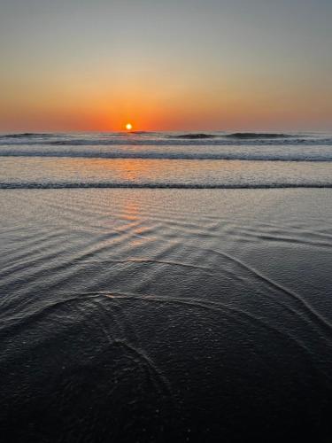 a sunset on the beach with ripples in the sand at Pacific View Condominium in Playa Azul in Playa Azul