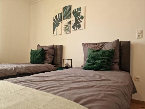 a bedroom with two beds with green pillows at Moselzauber Güls in Koblenz