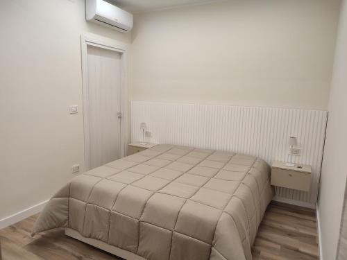 a white bedroom with a bed and two night stands at Nalí Guest House in Ercolano