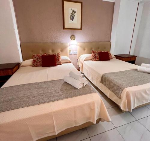 two beds in a hotel room with towels on them at Hotel Atlántico Centro in Santa Cruz de Tenerife