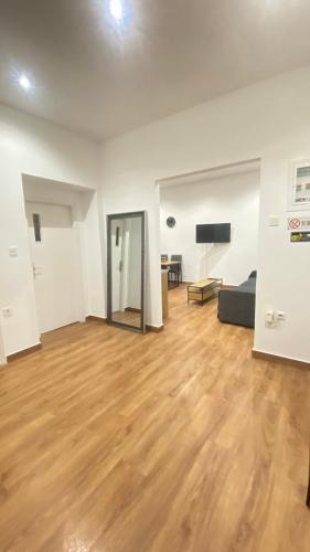 ein leeres Wohnzimmer mit Hartholzboden in der Unterkunft One Fine Stay in Piräus