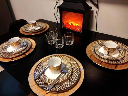 a table with three plates and cups and a fireplace at The Grass Residences in Manila