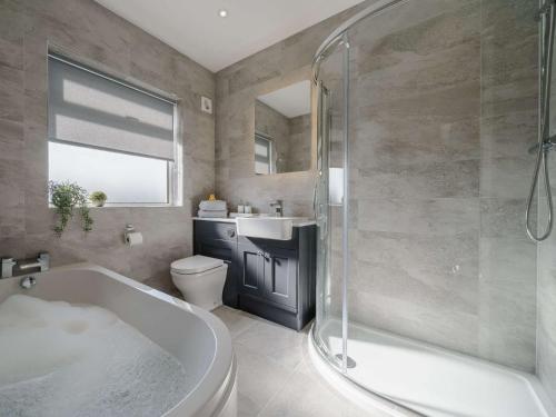 ein Badezimmer mit einer Badewanne, einem WC und einem Waschbecken in der Unterkunft 3 Bed in Cockermouth 82438 in Dearham