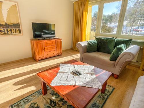 a living room with a couch and a coffee table at Między górami. Apartament w Cisnej in Cisna