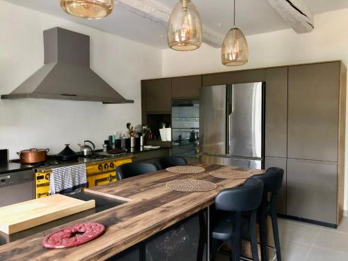 une cuisine avec une table en bois et quelques chaises dans l'établissement 140 du Ventoux, à Saint-Saturnin-lès-Avignon