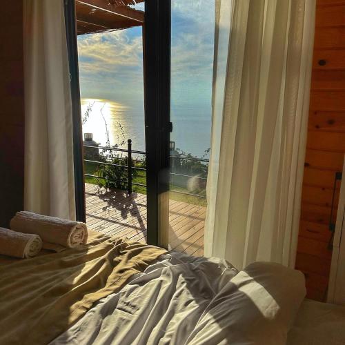 een slaapkamer met een bed en uitzicht op de oceaan bij Mesibu Bungalow 