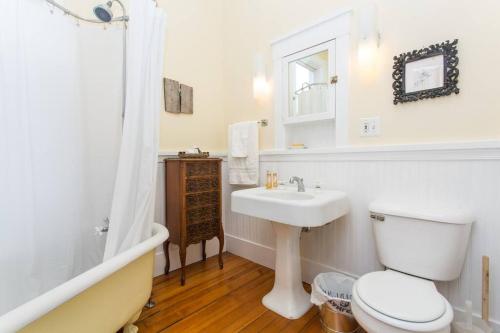 a white bathroom with a toilet and a sink at iKlektik House // Cardinal in Chicago