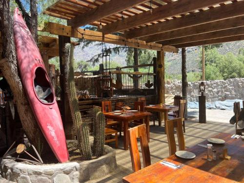 a restaurant with wooden tables and a red surfboard at Cabañas La Calchona in Melocotón