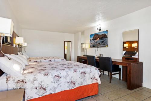 a hotel room with a bed and a desk at Temple View Inn in Ogden