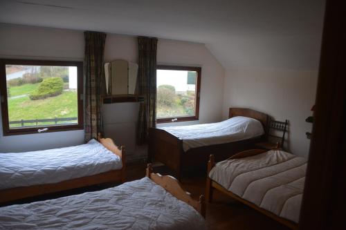 a room with three beds and a window at B&B La Source Houffalize in Houffalize