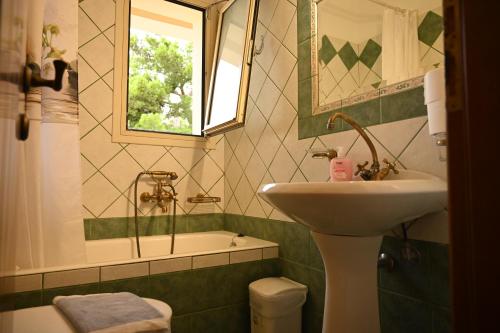 W łazience znajduje się umywalka i wanna. w obiekcie liocharis villas w mieście Lourdata