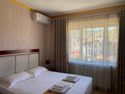 a bedroom with a bed and a large window at British Hotel Pogradec in Pogradec