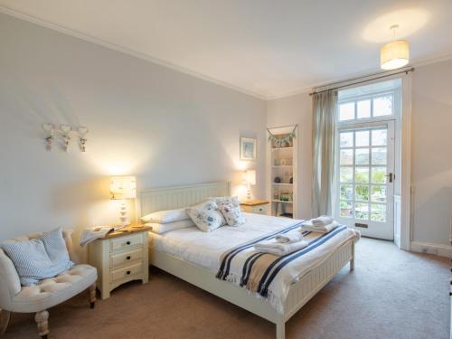 a bedroom with a bed and a chair and a window at 3 Bed in Sawrey 62587 in Far Sawrey