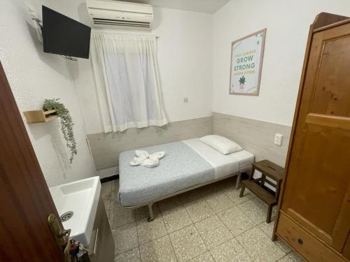 a small bedroom with a bed and a sink at Pensión Fortea in Zaragoza