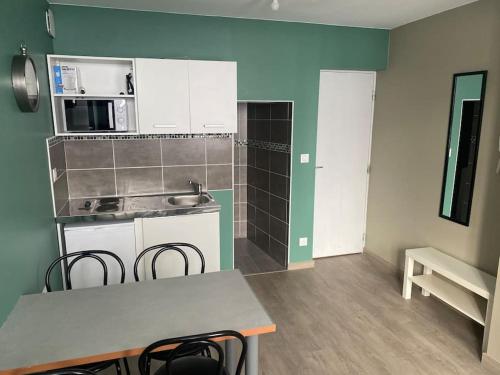 une cuisine avec une table et des chaises dans une pièce dans l'établissement Appartement 3 - Hyper centre - 1 à 4 personnes, à Douai