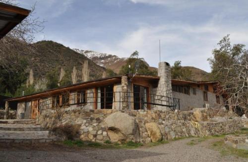 an old stone house with a stone wall at Cabañas La Calchona in Melocotón