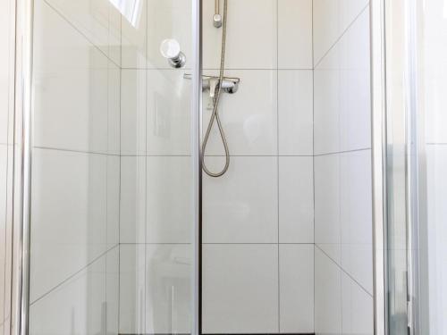 a shower stall with a glass shower door at Chalet in Brabant with Spacious Garden in Veldhoven