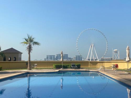 una gran piscina con una noria en el fondo en Pure Sand - Luxury Hostel JBR Dubai en Dubái