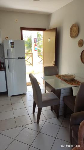 a kitchen with a table and a white refrigerator at CONDOMÍNIO VILA DO MAR in Aquiraz