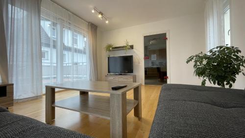 a living room with a table and a tv at Fewo Reutlingen Heinestrasse in Reutlingen
