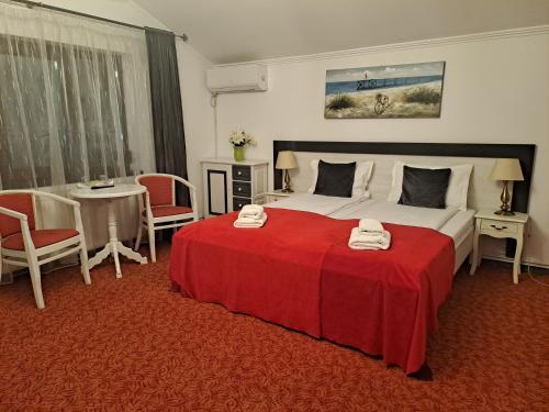 a bedroom with a large bed with a red blanket at Alexander House in Deva