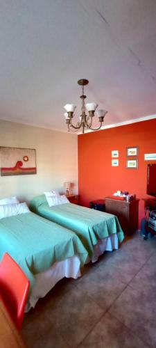 2 letti in una camera d'albergo con pareti rosse di Habitación de huéspedes con entrada independiente a Concordia