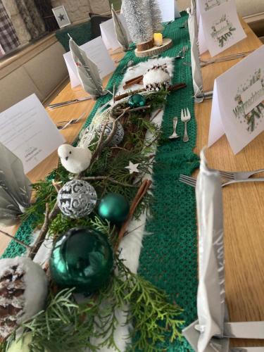a table with christmas decorations on a green table cloth at Zur neuen Post Landgasthof in Herzogsreut