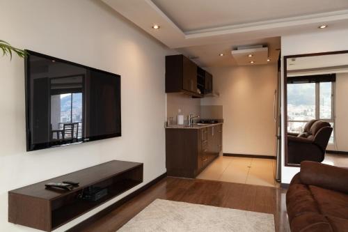 a living room with a large flat screen tv on the wall at Olympus Apartments in Quito