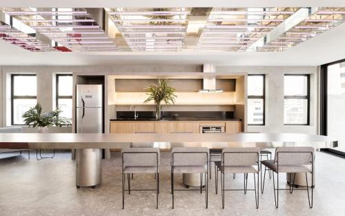 a large kitchen with a large table and chairs at Housi Paulista in Sao Paulo