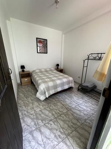 a bedroom with a bed and a tiled floor at Morada Apart in Tacna