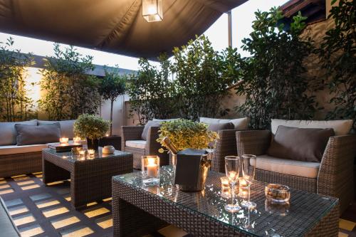 a patio with wicker chairs and tables with candles at Tornabuoni Suites Collection Residenza D'Epoca in Florence